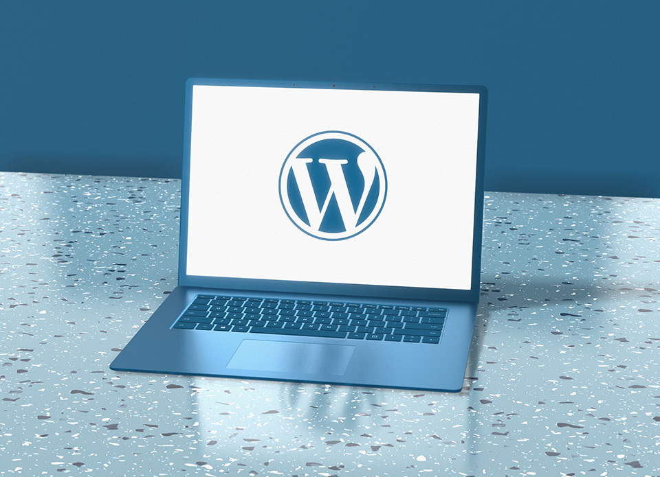 The WordPress logo on the laptop screen